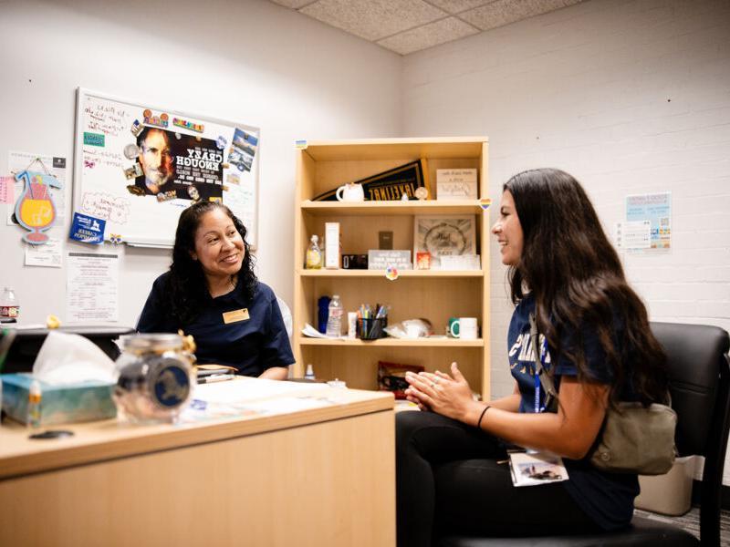 A student meets with a Success Coach in the success coach's office.