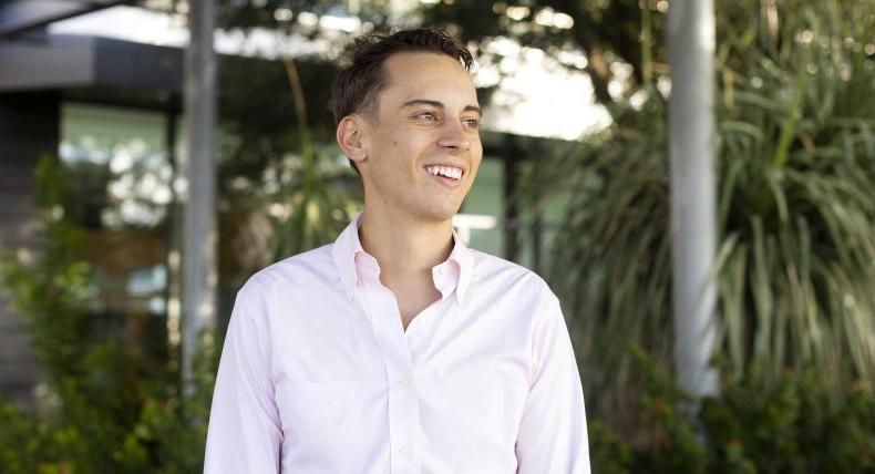 Christoph Hoermann smiles and stands on the Austin Public Library green rooftop patio.