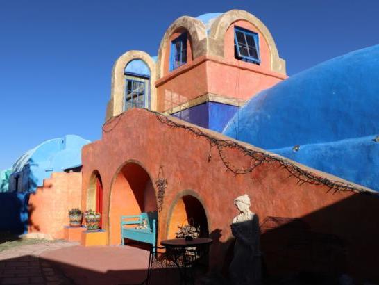 An orange and blue painted building with rounded rooftops and entrances