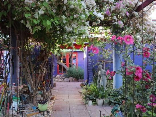 An outdoor garden with a statue of a woman and flowers all around