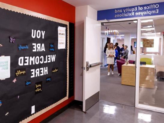 The entrance to the Office of Equity and Employee Relations. A bulletin board outside the office reads YOU ARE WELCOMED HERE.