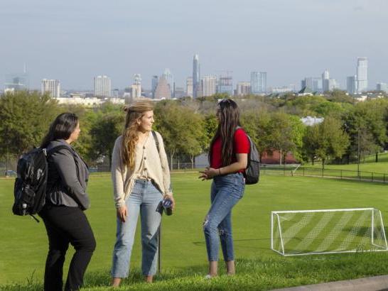 Students talking above the soccer field overlooking downtown Austin